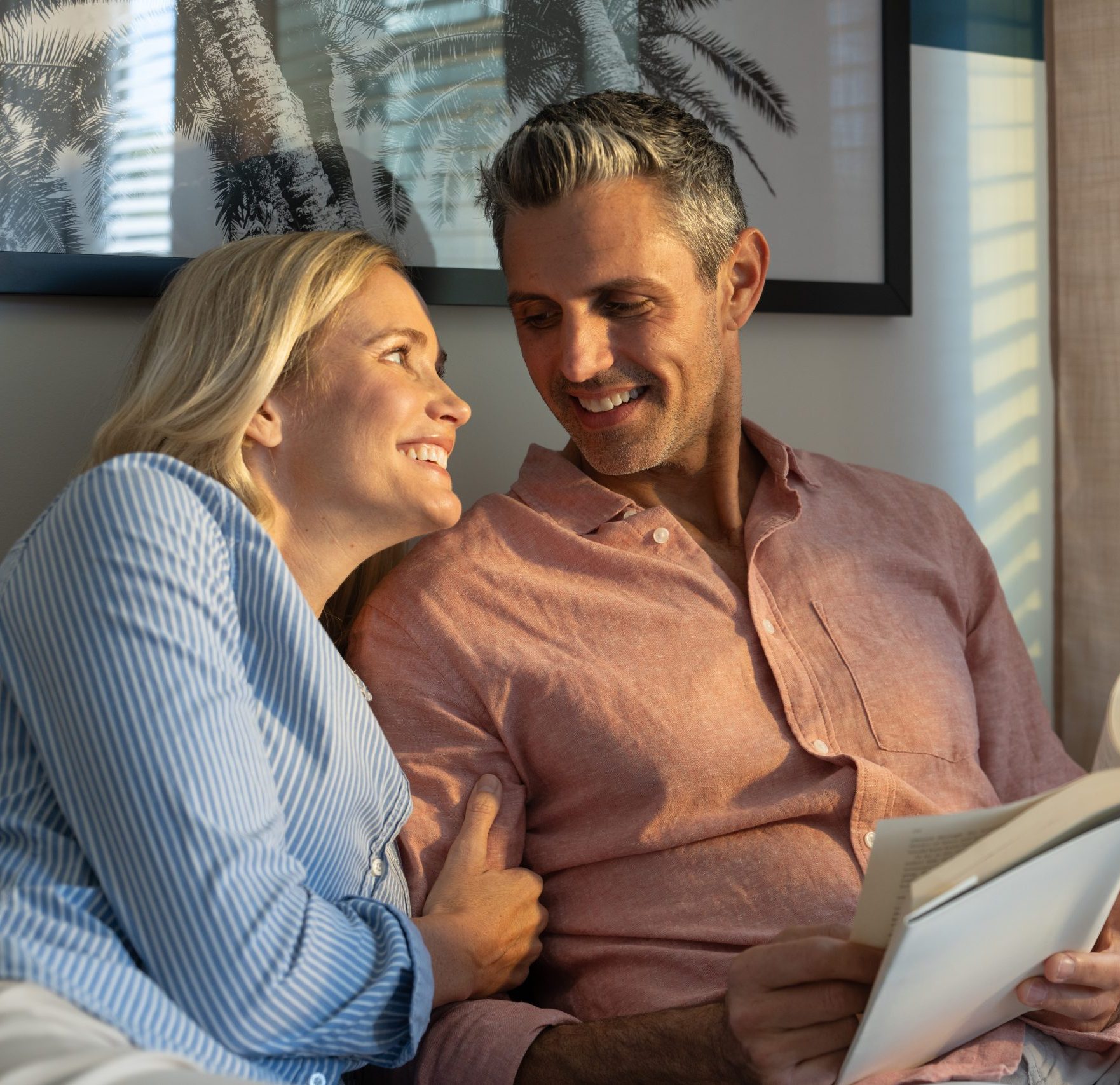 Man and woman reading a book in apartment home at Alton Osprey